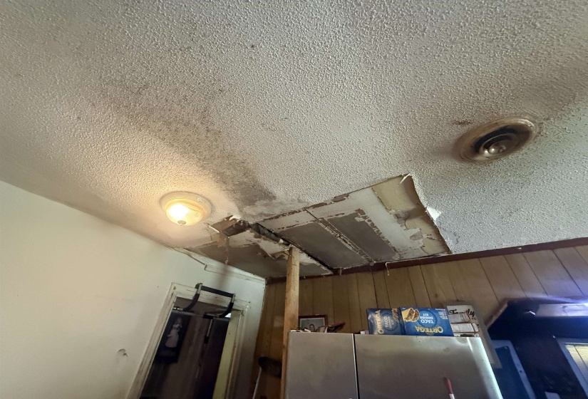 Detailed view of a textured ceiling and stainless steel refrigerator