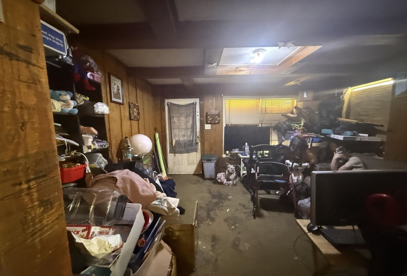 Miscellaneous room with wooden walls and unfinished concrete floors