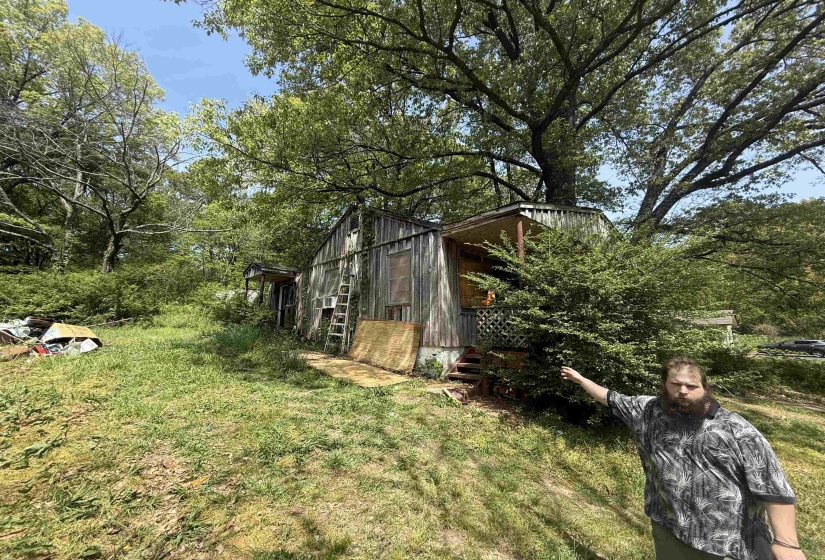 View of grassy yard featuring view of wooded area