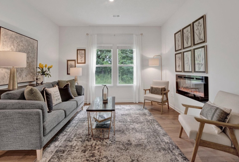 Living room featuring light wood finished floors and a glass covered fireplace