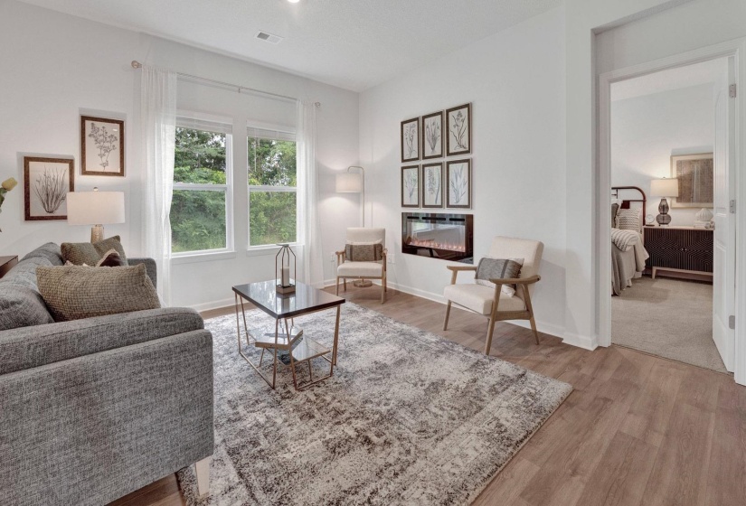 Living area featuring light wood-style floors and a glass covered fireplace