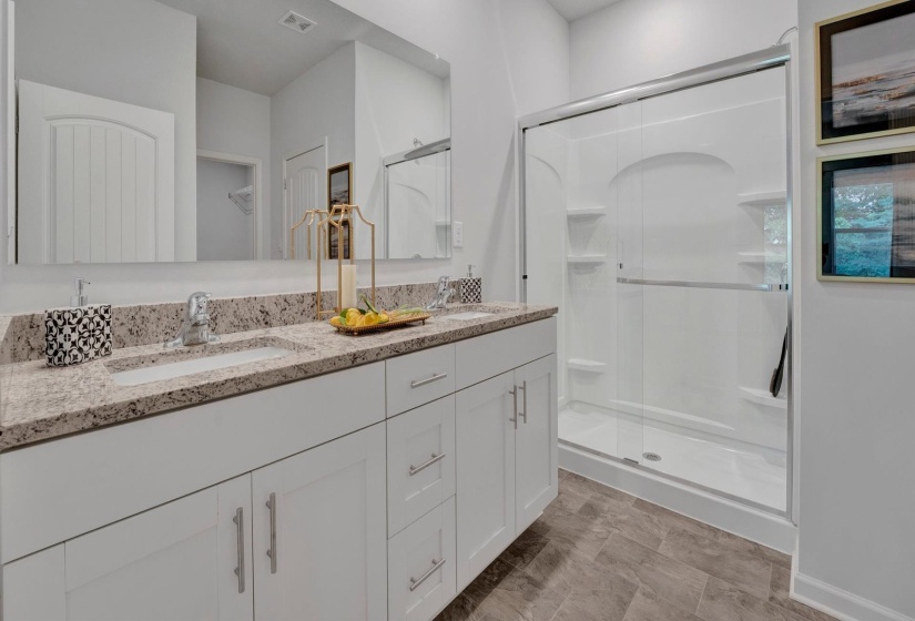 Bathroom featuring a stall shower and double vanity