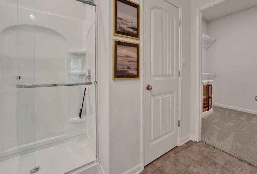 Bathroom with a shower stall and baseboards