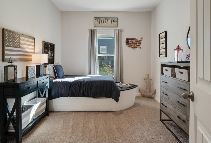 Bedroom with light colored carpet and baseboards