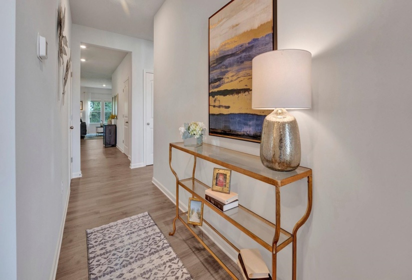 Hallway with light wood-style floors and baseboards