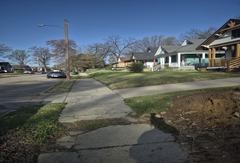 View of green lawn with a porch and a residential view