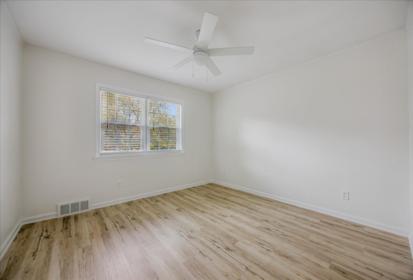 Empty room featuring light wood-style floors and ceiling fan