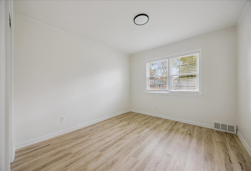 Spare room featuring light wood finished floors and baseboards