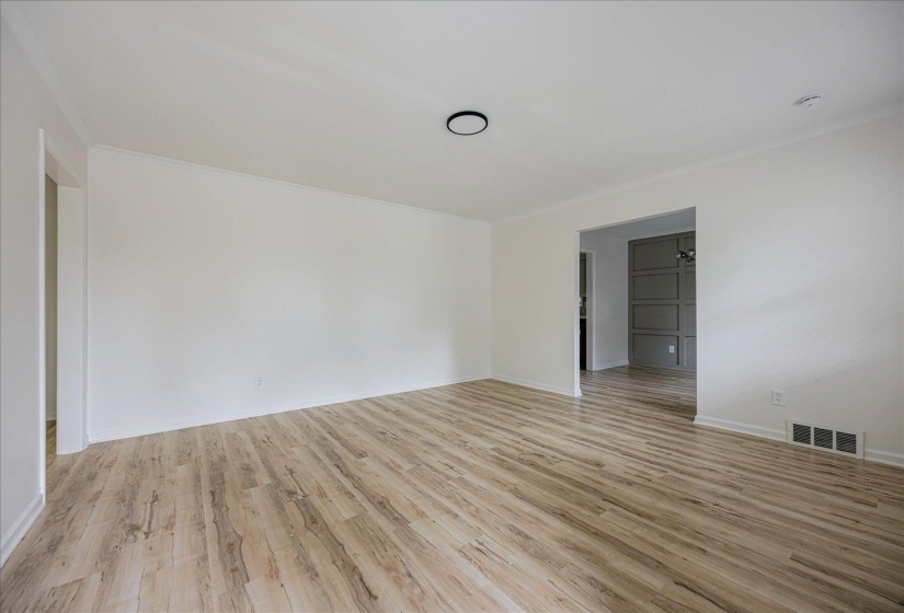 Empty room with light wood finished floors and ornamental molding