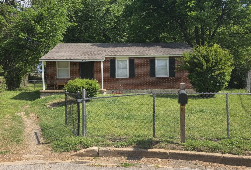 Ranch-style home with a fenced front yard, brick siding, a gate, and roof with shingles