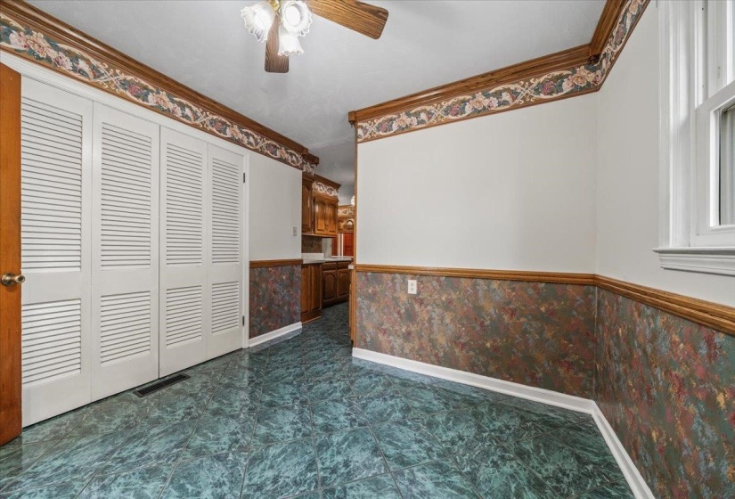 Interior space featuring a wainscoted wall, ornamental molding, wallpapered walls, and a ceiling fan