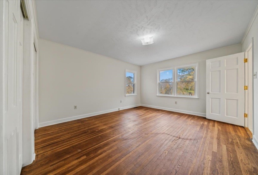 Unfurnished bedroom with dark wood-style floors and a textured ceiling