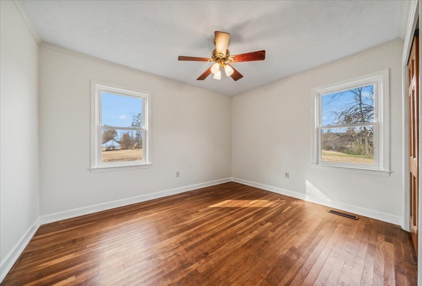 Spare room featuring ornamental molding, dark wood-type flooring, and a ceiling fan