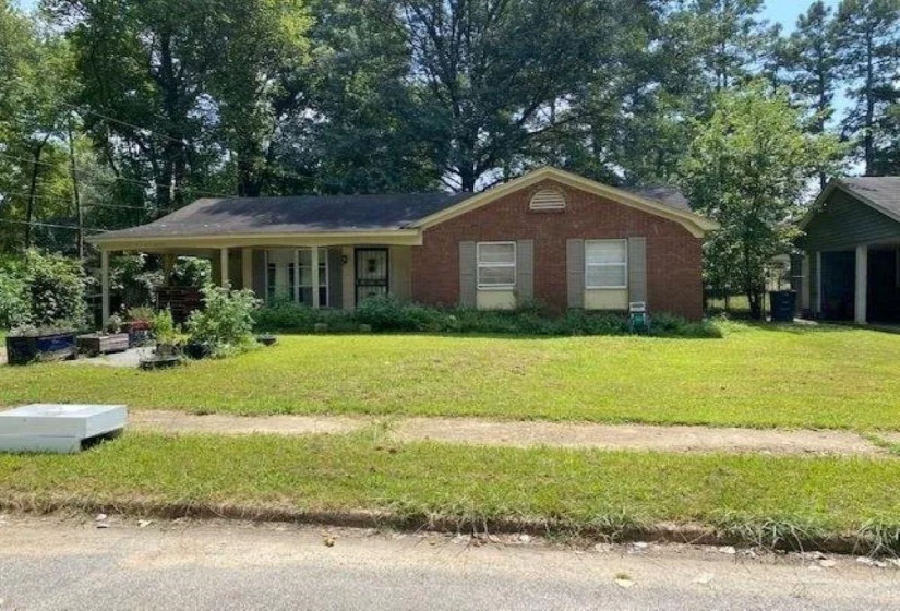 Single story home with a porch and a front yard