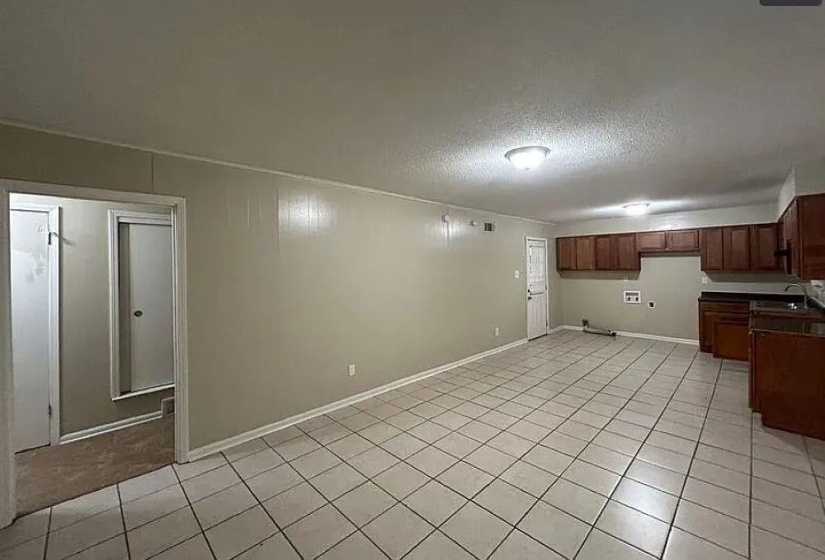 Finished below grade area featuring a textured ceiling and light tile patterned floors