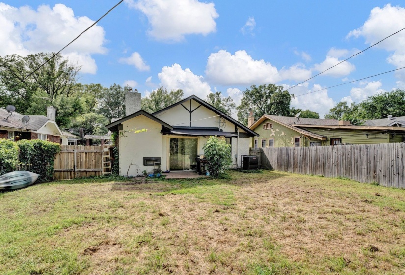Rear view of house featuring a fenced backyard, a patio area, a chimney, and stucco siding