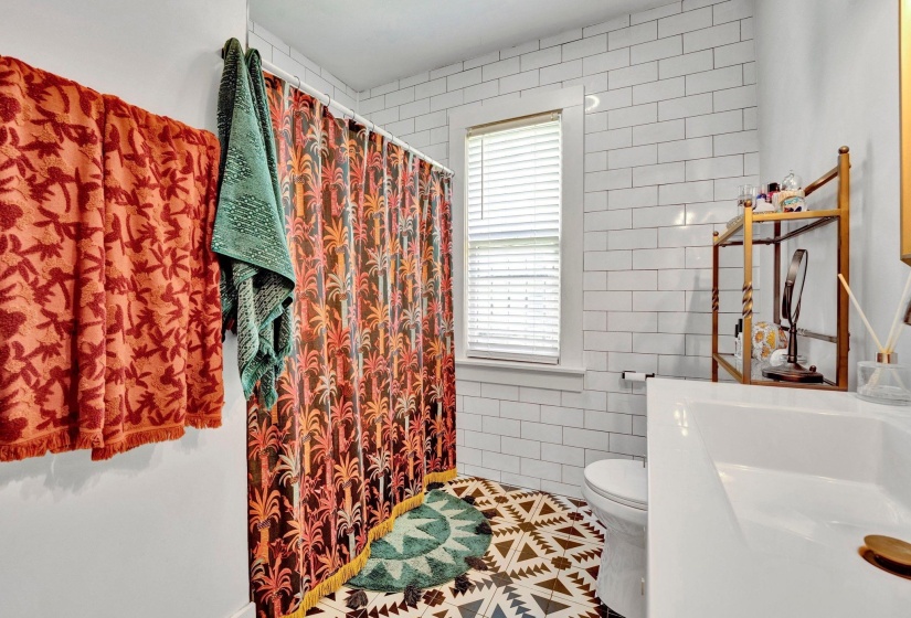 Full bath featuring tile walls, curtained shower, vanity, and tile patterned flooring
