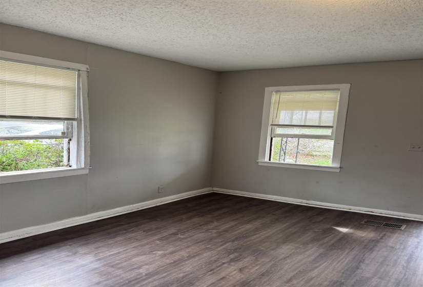 Empty room featuring dark wood finished floors and a textured ceiling