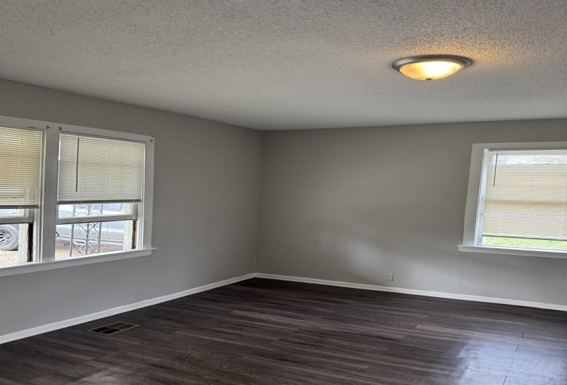 Spare room featuring dark wood finished floors and a textured ceiling