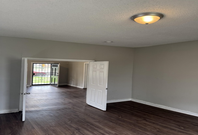 Spare room featuring dark wood-style flooring and a textured ceiling