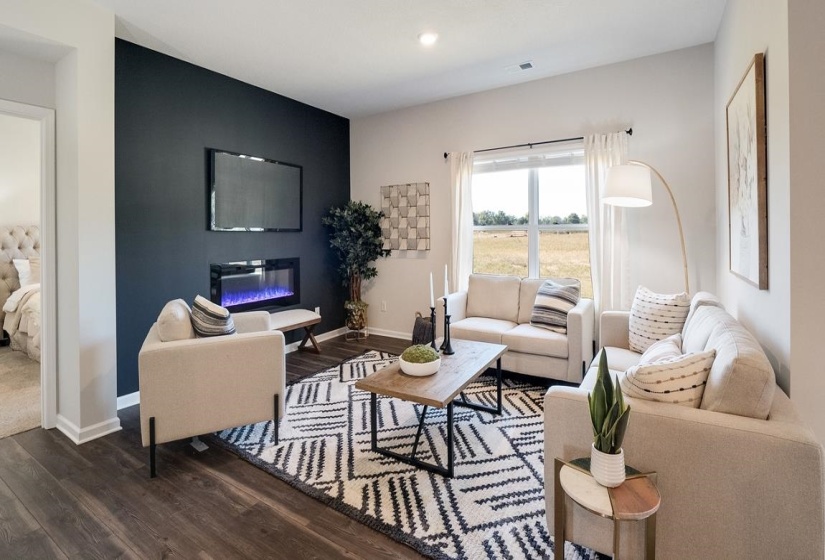 Living area featuring a glass covered fireplace, dark wood-style floors, and recessed lighting