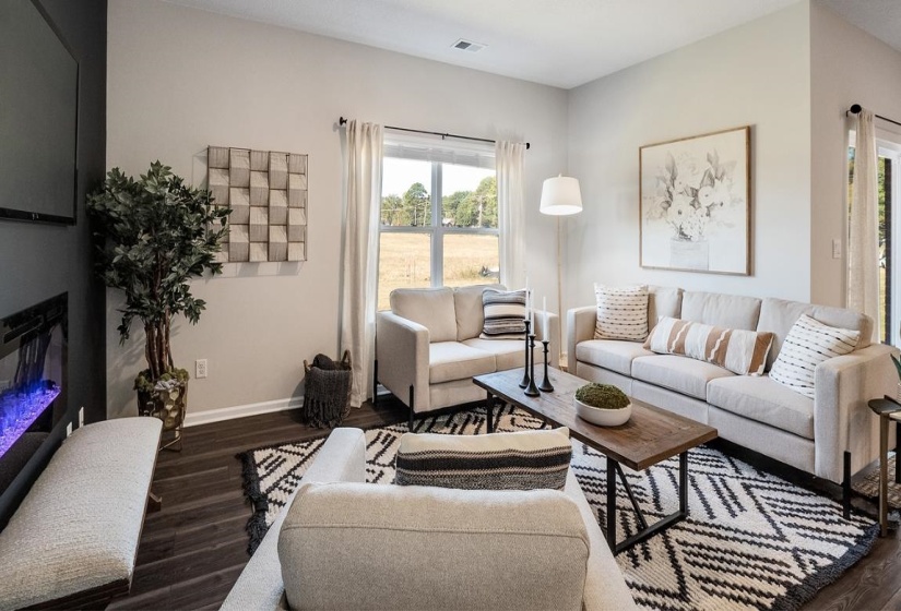 Living area featuring dark wood-type flooring and a glass covered fireplace