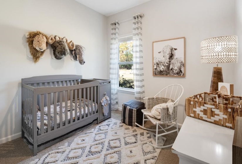 Carpeted bedroom featuring a crib and baseboards