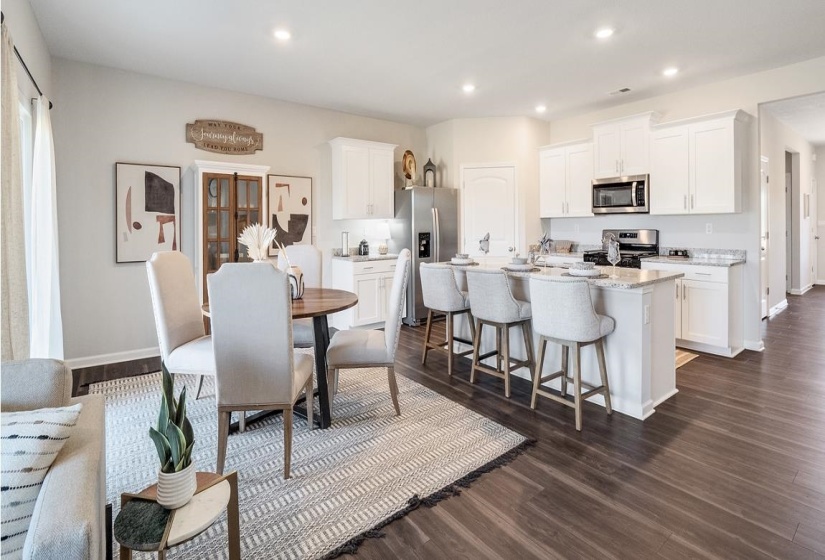 Dining area with dark wood-type flooring and recessed lighting