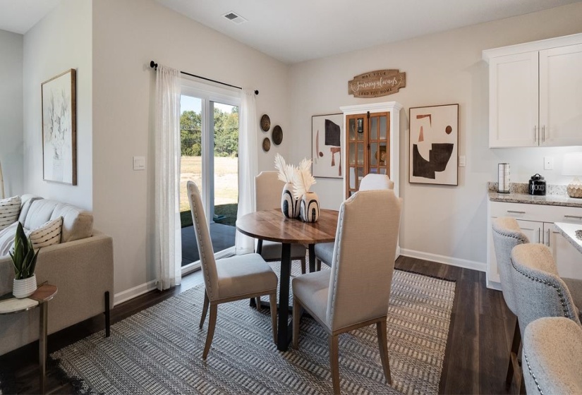Dining room with dark wood-style flooring and baseboards
