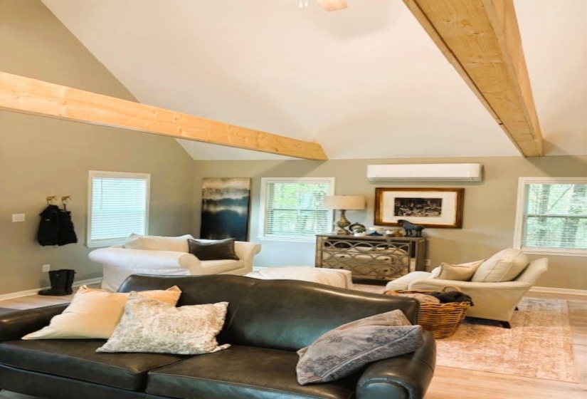 Living room with light wood-style floors, lofted ceiling, and plenty of natural light