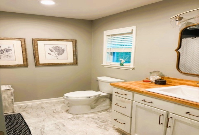 Bathroom with vanity, a shower with shower curtain, and light marble finish floors