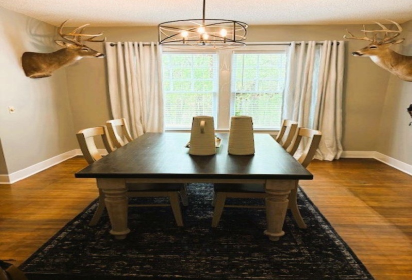 Dining area with a chandelier, dark wood finished floors, and a textured ceiling