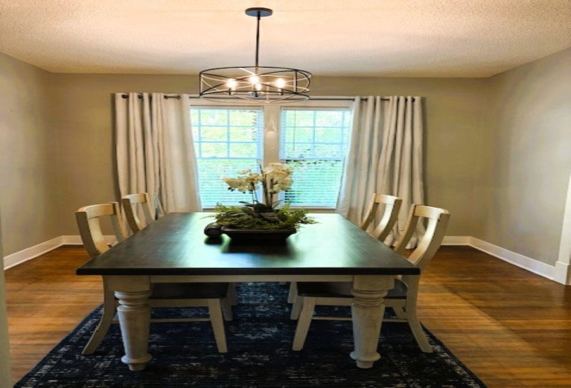 Dining area featuring a textured ceiling, dark wood-type flooring, and a chandelier