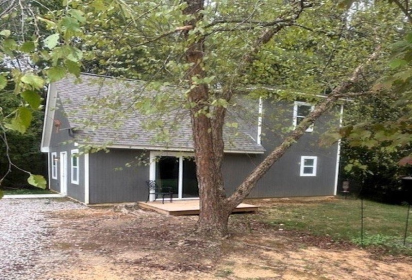 Rear view of house with a deck and a shingled roof