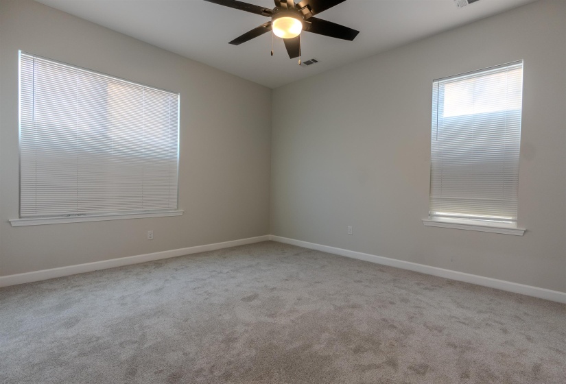 Carpeted spare room featuring ceiling fan