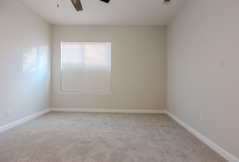 Carpeted empty room with ceiling fan