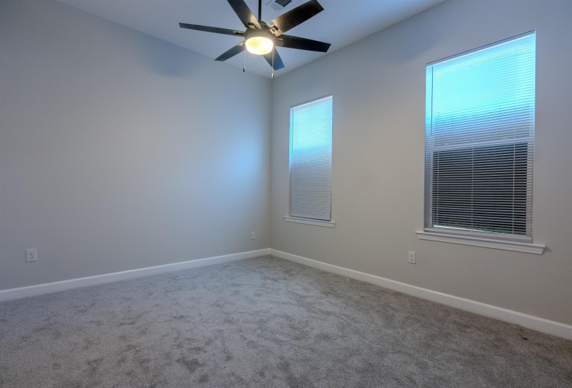 Empty room featuring ceiling fan and carpet flooring