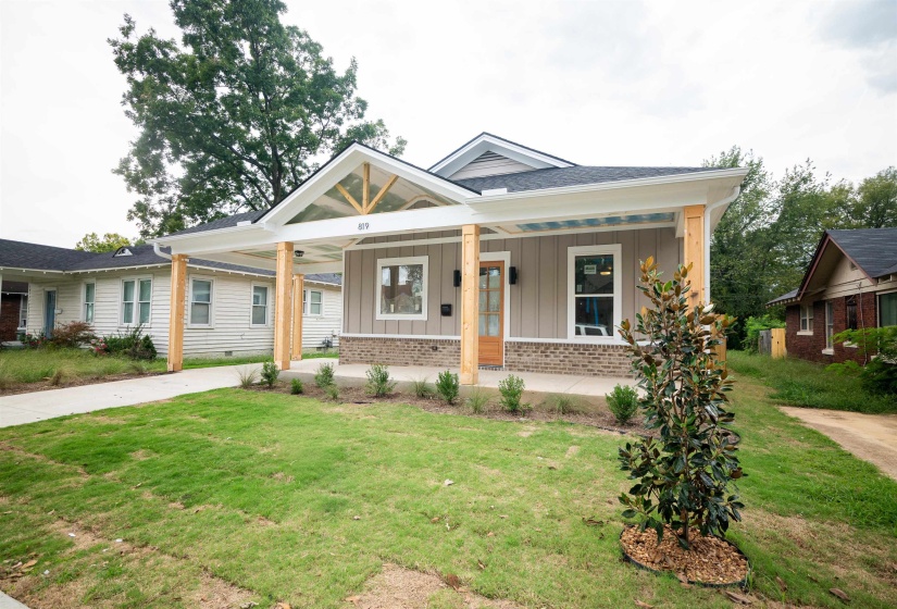 View of front facade with covered porch and a front lawn