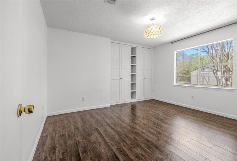 Empty room featuring dark wood-style flooring and a textured ceiling