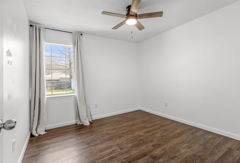 Spare room with dark wood-type flooring and ceiling fan