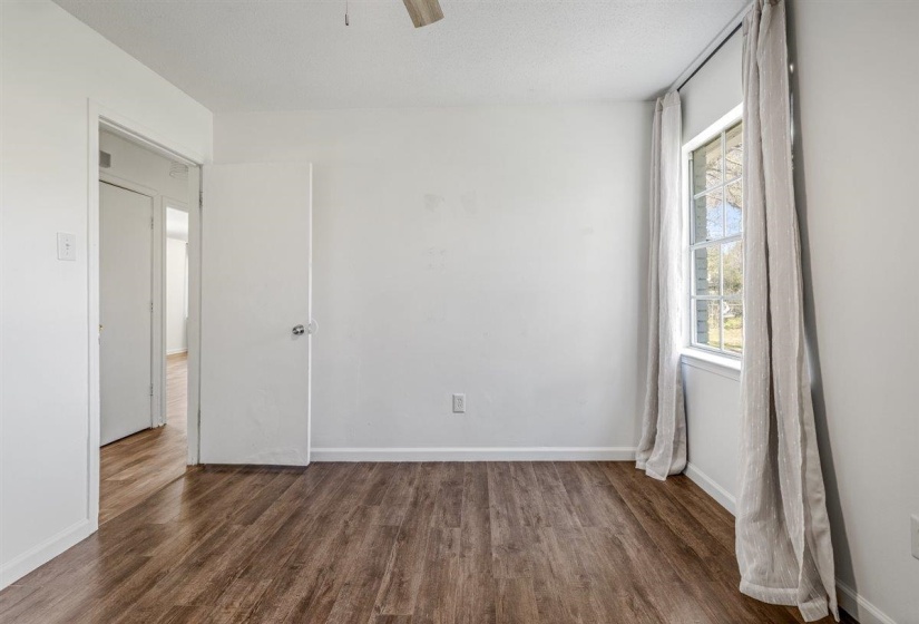 Spare room with dark wood-style flooring and a ceiling fan