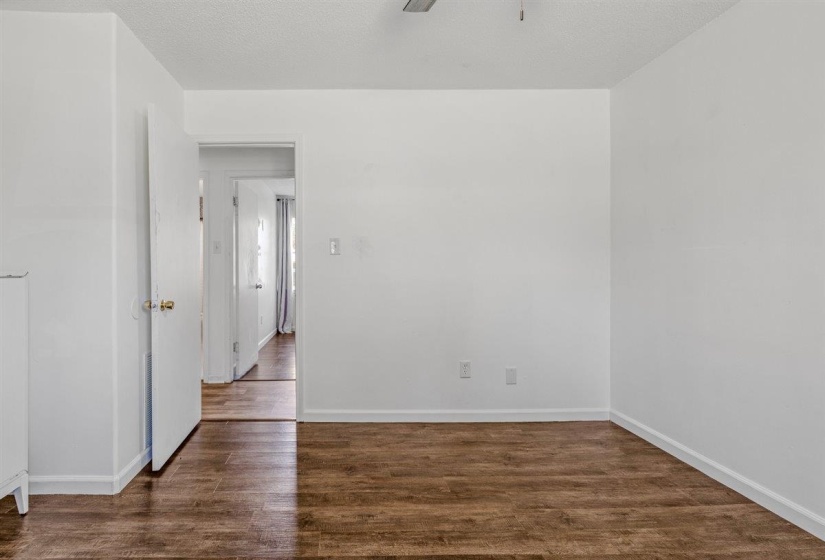 Spare room featuring dark wood-style floors, a textured ceiling, and a ceiling fan