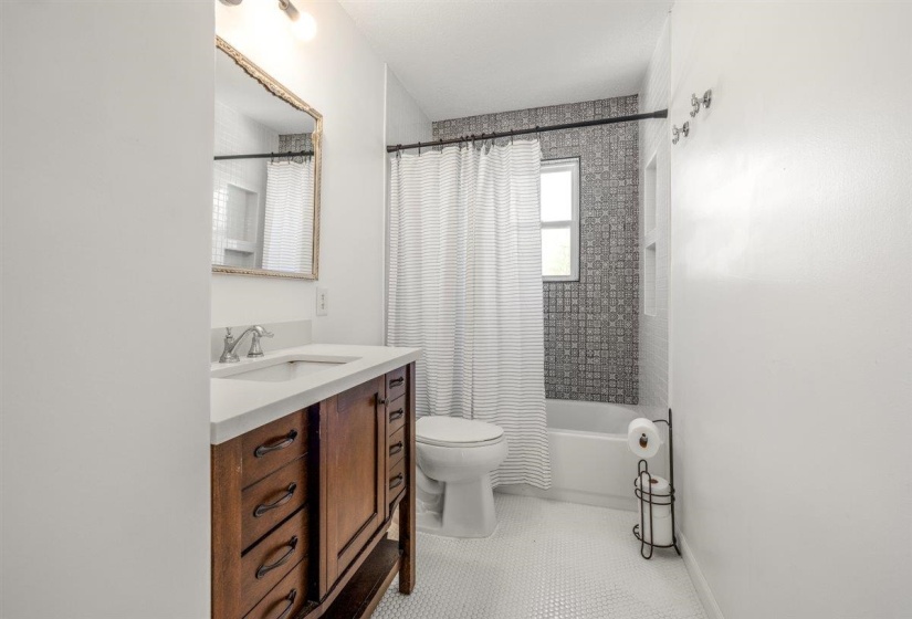 Bathroom featuring vanity, shower / tub combo with curtain, and light tile patterned floors