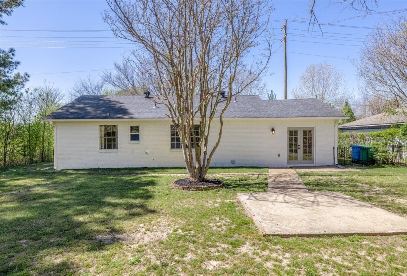 Rear view of house with french doors, brick siding, and a lawn