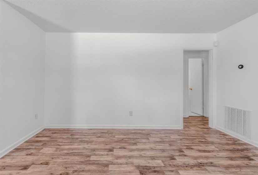 Unfurnished room featuring light wood finished floors and a textured ceiling