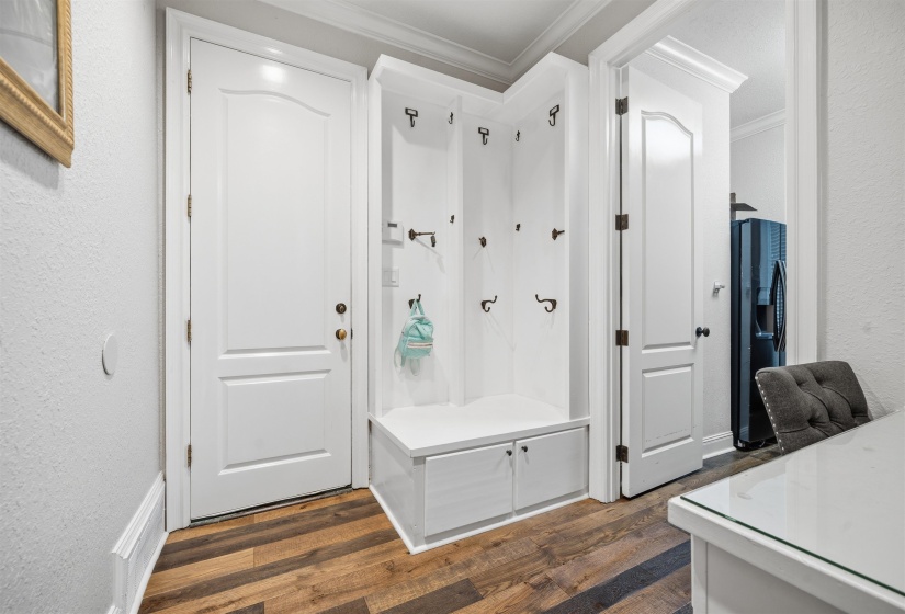 White built-in hall tree featuring multiple storage compartments and coat hooks