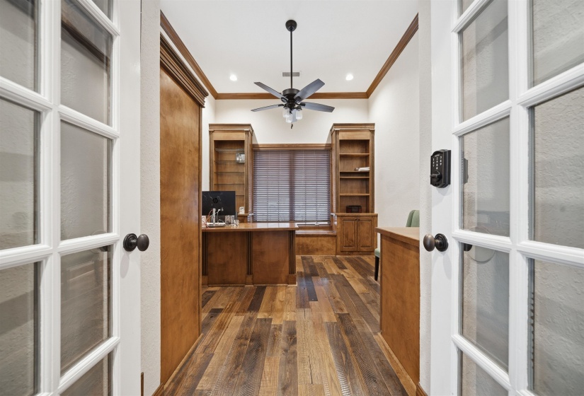 Room featuring wood-finish flooring, built-in shelving, a ceiling fan, recessed lighting, and a window with blinds
