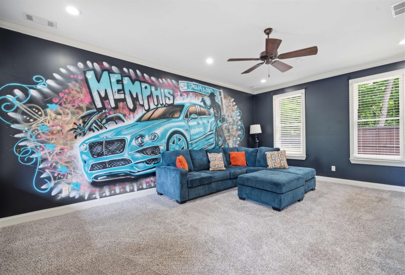 Expansive room featuring a unique wall mural, recessed lighting, and a ceiling fan
