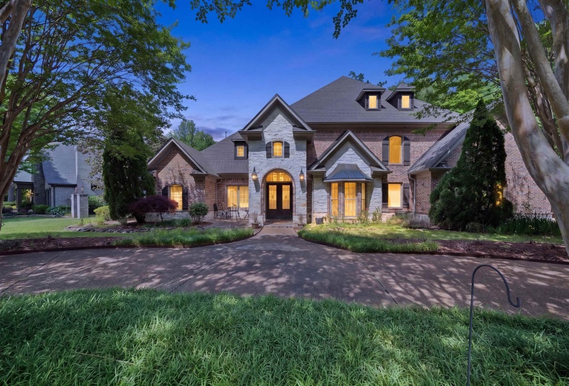 Stately brick and stone exterior with architectural dormers and a prominent arched entry