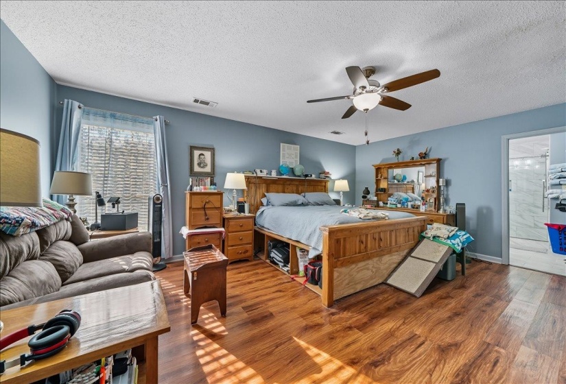 Bedroom featuring wood finished floors, a textured ceiling, and a ceiling fan